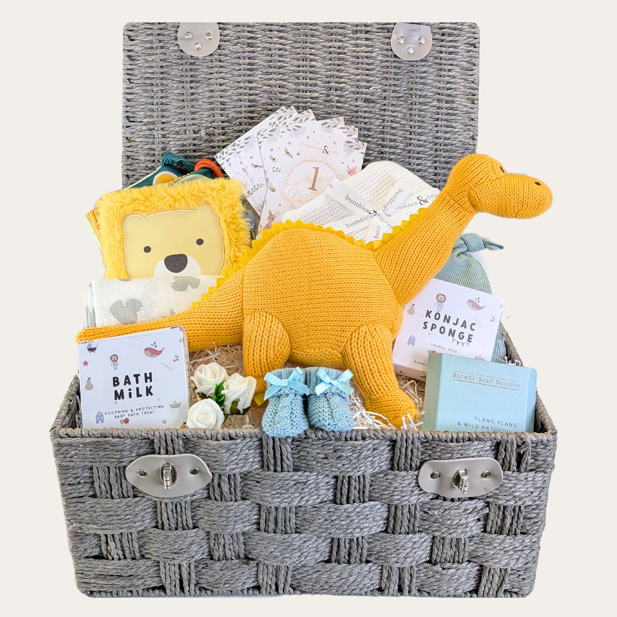 Large baby boy hamper with gifts including yellow organic knit dinosaur and blue baby booties.