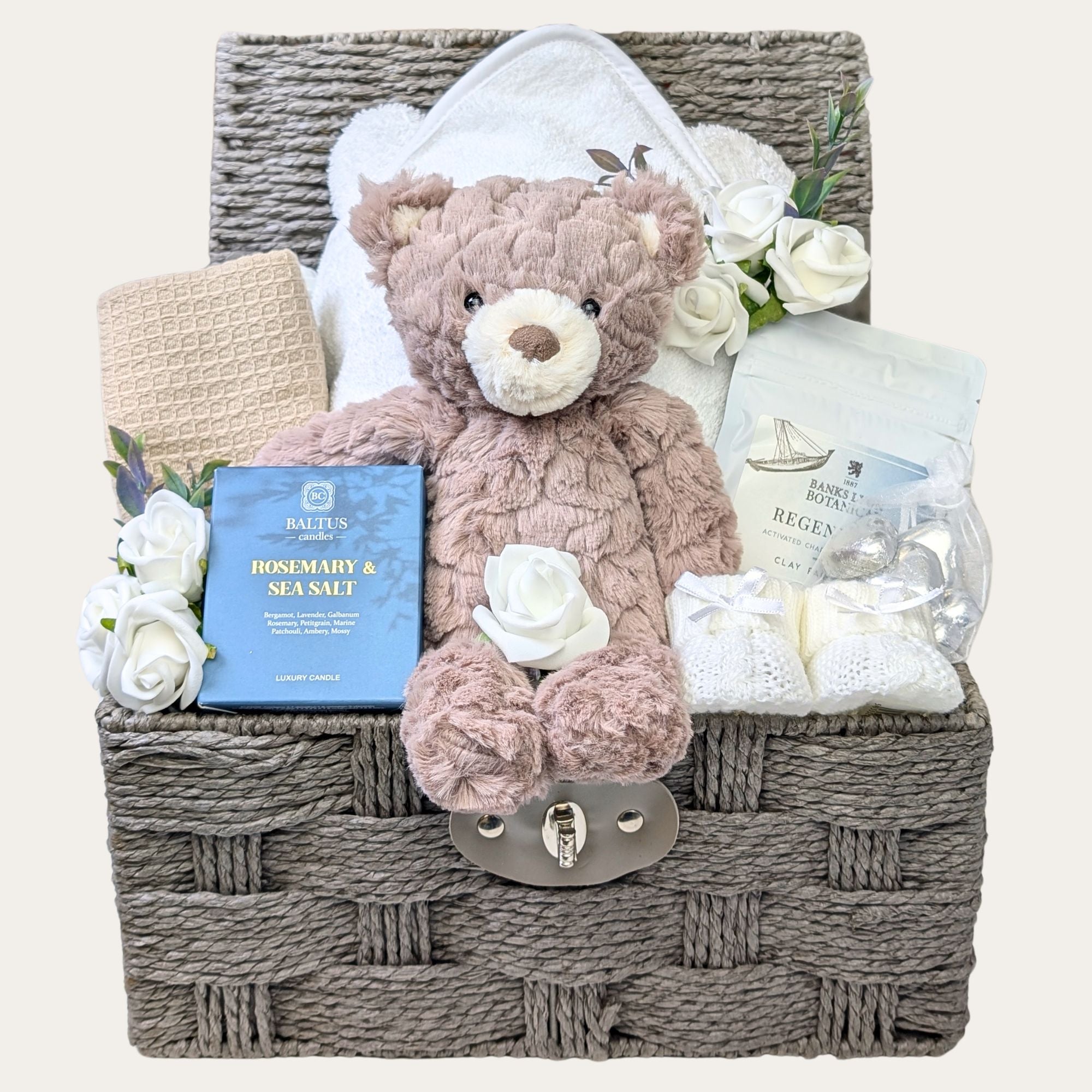 Luxury mummy-to-be hamper in a natural grey rope basket featuring milk chocolates, organic face mask, relaxation candle, cotton flannel, knit baby booties, hooded baby bath robe with bear ears, traditional teddy bear, and keepsake hamper basket.