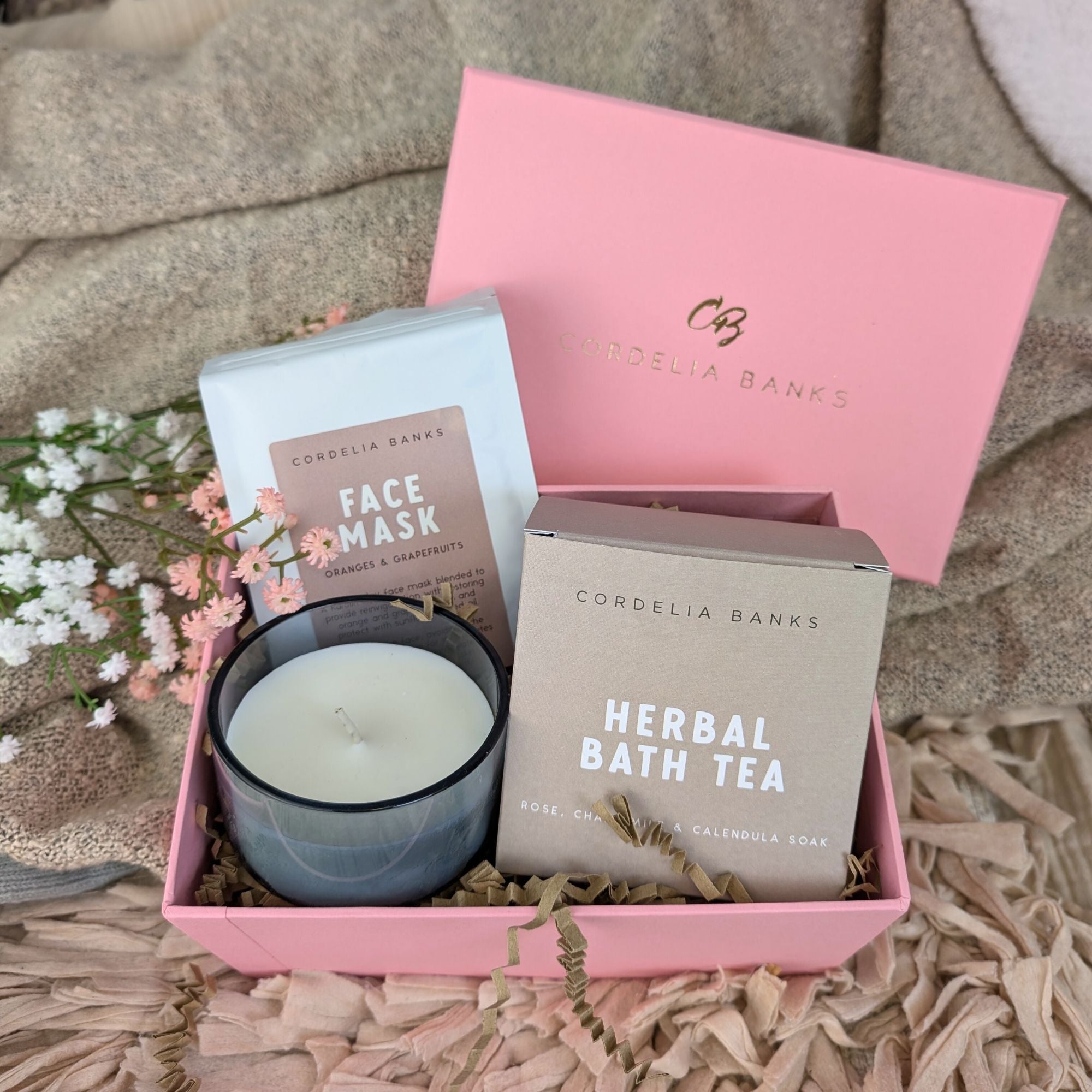 pink gifts box which includes face mask, candle and herbal bath tea