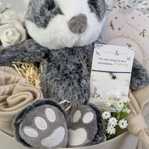 new baby gifts box with a farmyard badger, baby booties, baby hat, baby bib, milestone cards and a bracelet for mum