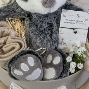 new baby gifts box with a farmyard badger, baby booties, baby hat, baby bib, milestone cards and a bracelet for mum