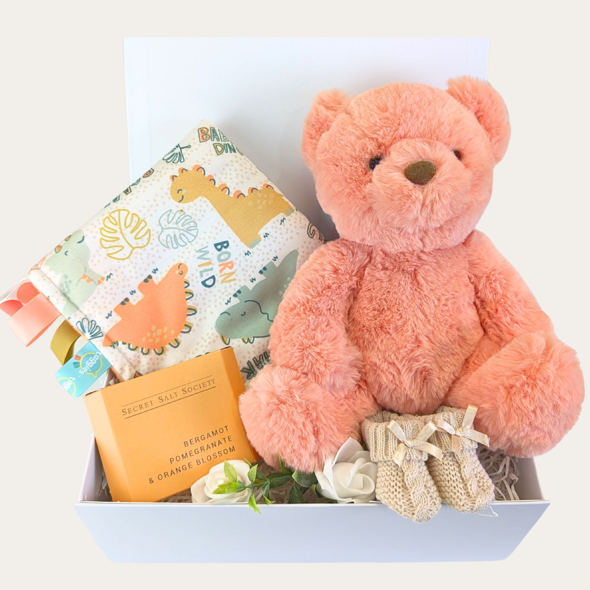 New baby boy gift hamper box with orange gifts of a teddy and taggie toy. 