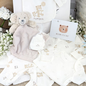 Baby shower gifts bag with white baby clothes set and puppy baby comforter toy.