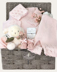 new baby girl gifts hamper basket with pink knit clothing, lamb soft toy, baby booties and a bracelet for mum.