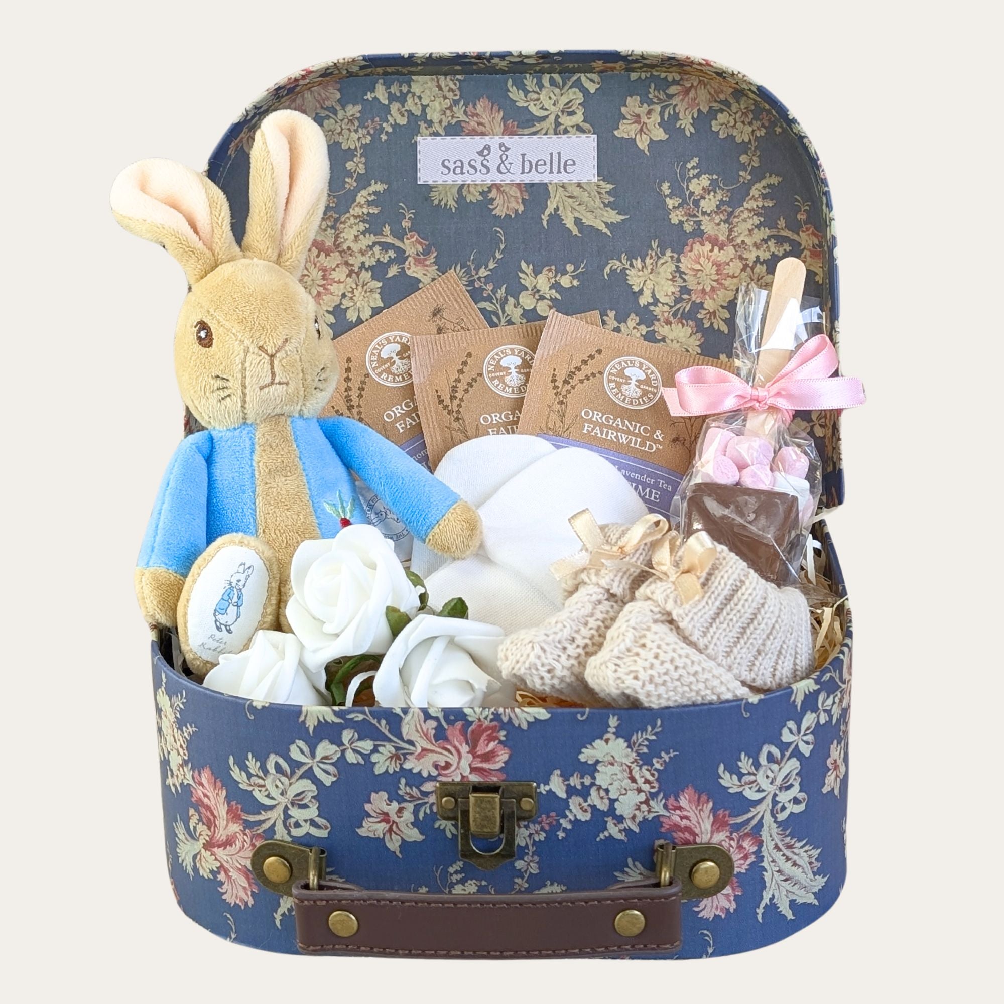 Baby gifts in a floral hamper with Peter Rabbit toy.