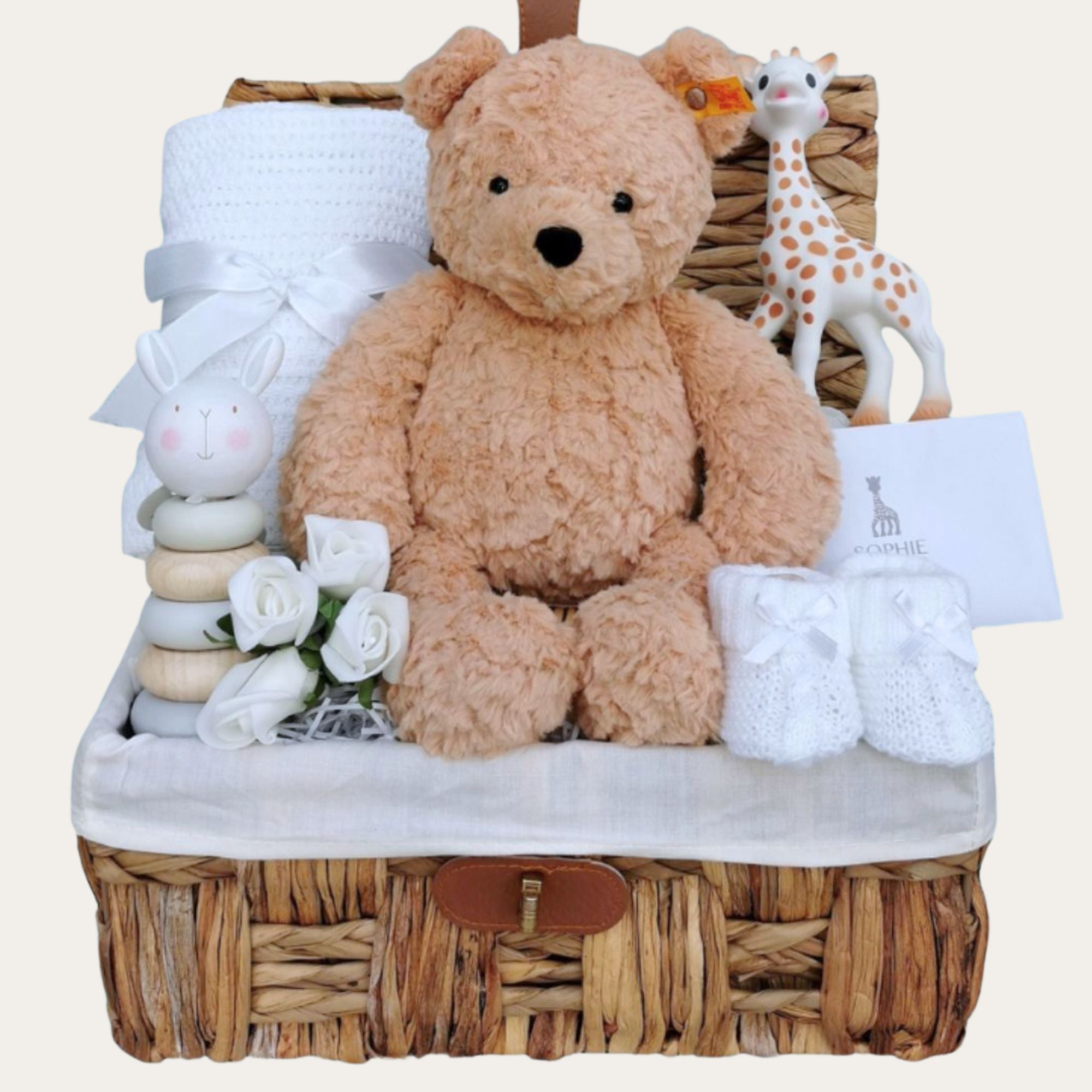 baby gifts hamper with steiff teddy bear, baby blanket, wooden toy and sophie giraffe teething toy.