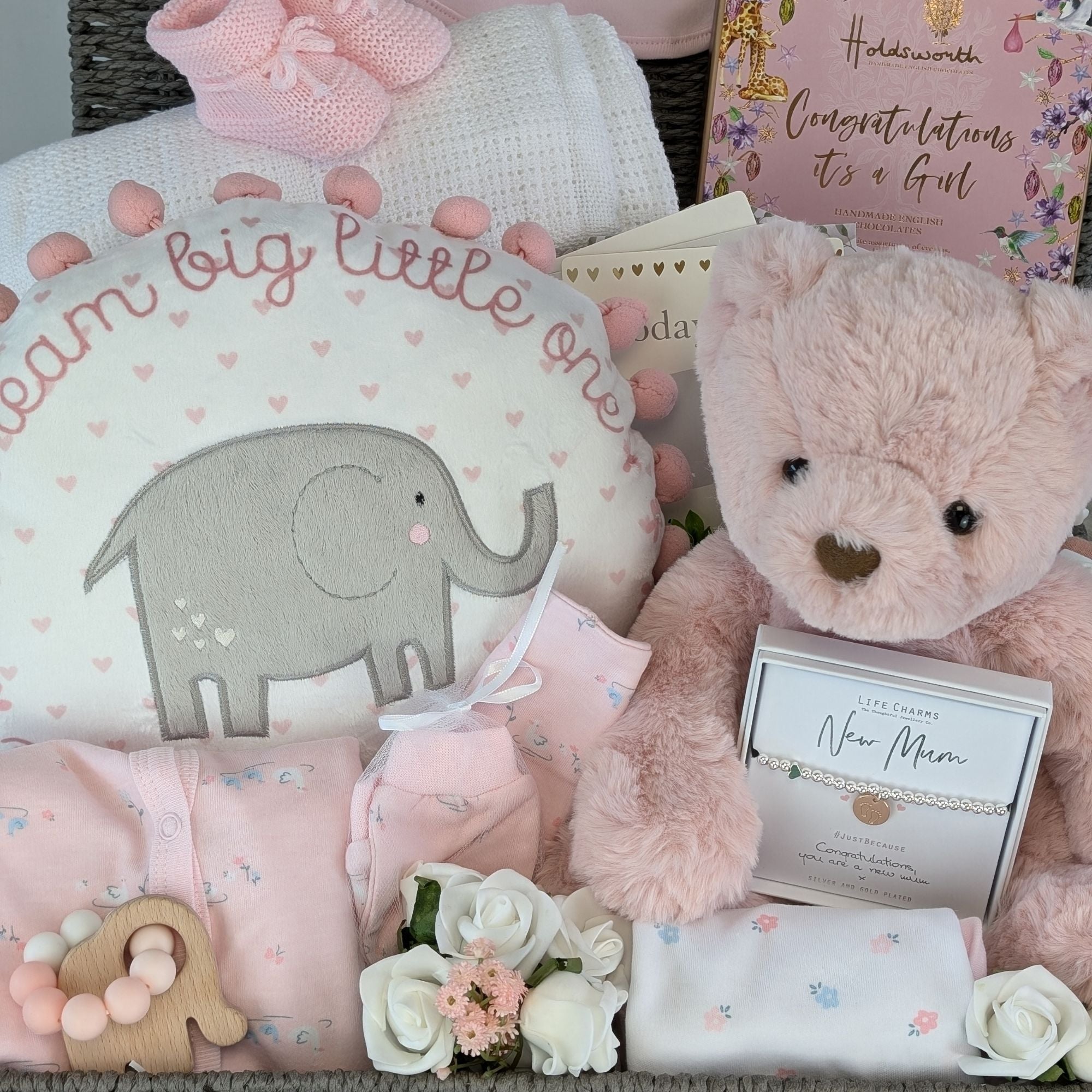 a large new mum hamper basket which includes chocolates, bracelet, reddy bear, teething toy, clothing set, blanket, booties and keepsake basket.