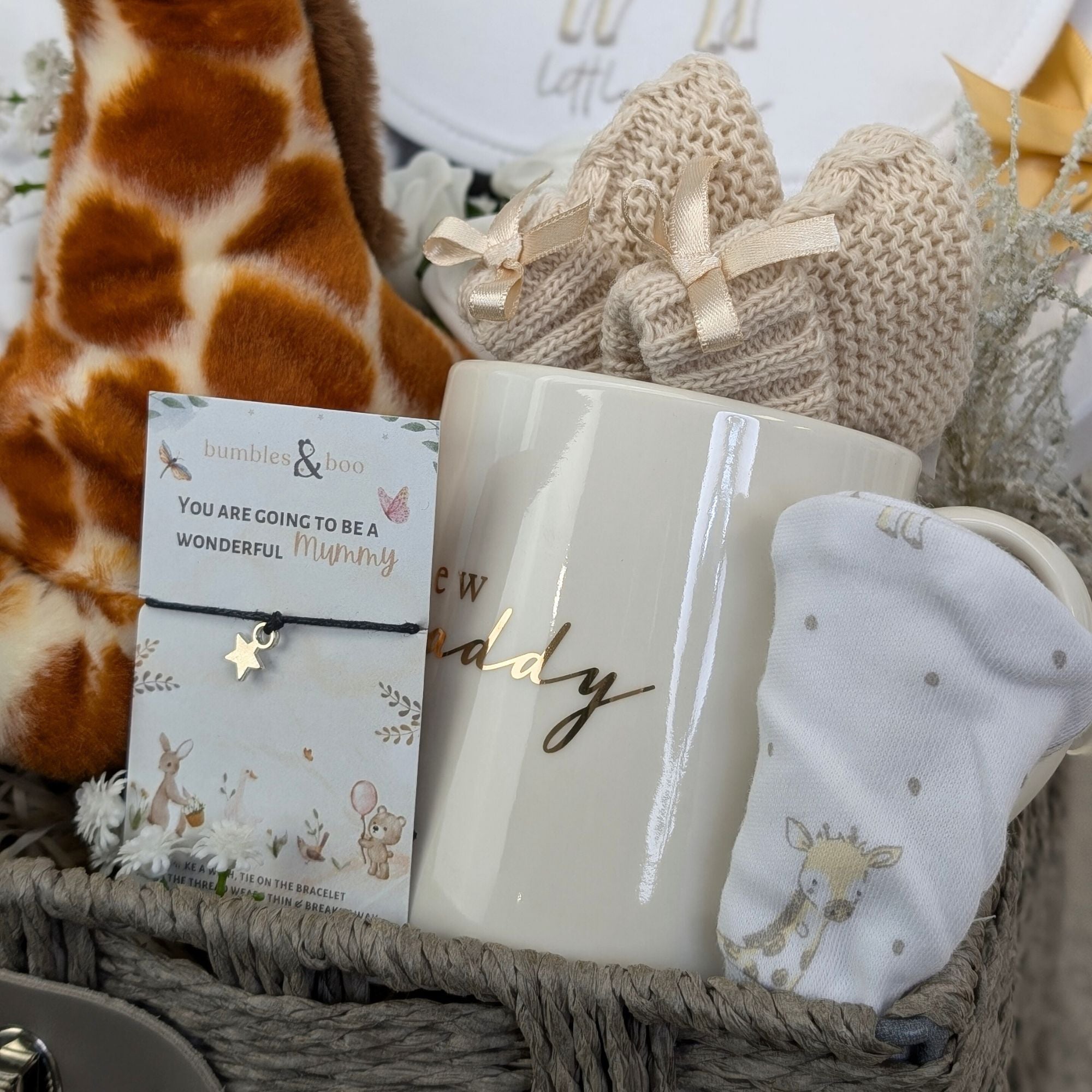 new mum gifts basket with giraffe theme baby clothing, giraffe soft toy, chocolates, baby booties, mug for daddy and wish bracelet for mummy