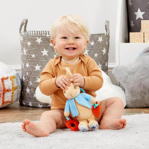 baby playing with peter rabbit soft activity toy with teething accessories. bumbles and boo. 