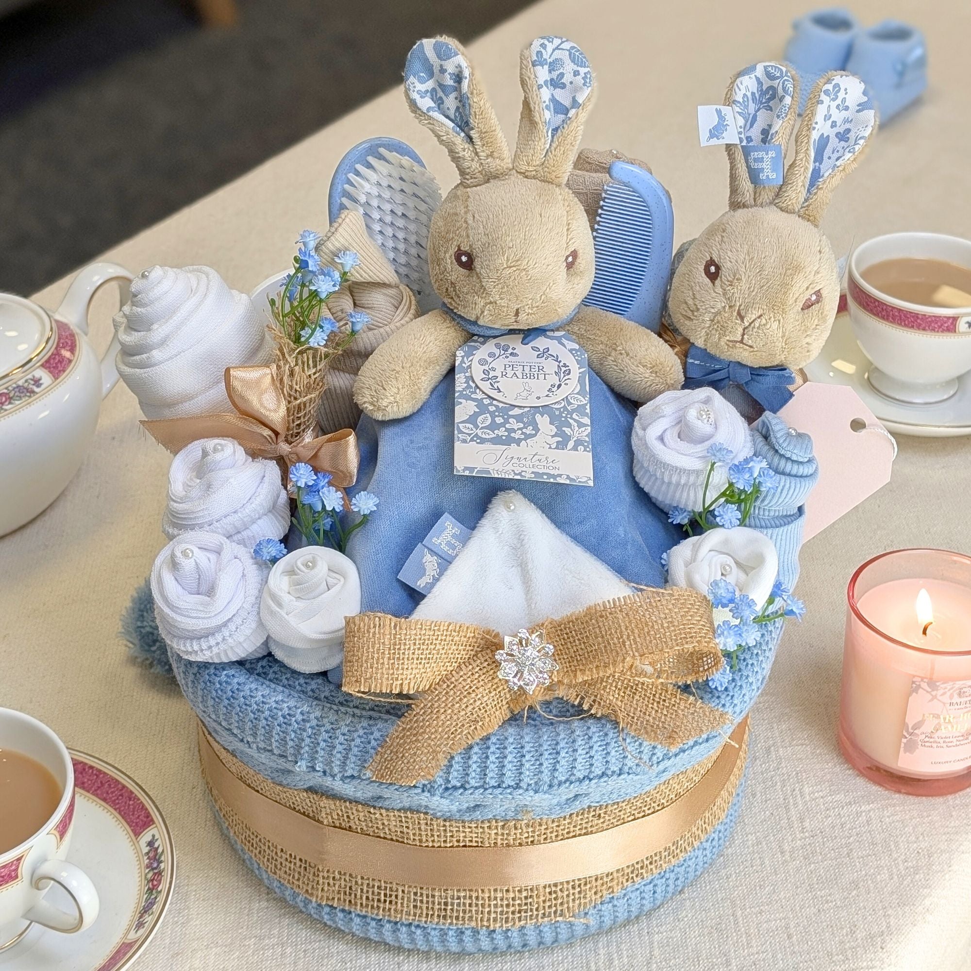 peter rabbit themed baby nappy cake with blanket, comforter, clothing and baby rattle. bumbles and boo.