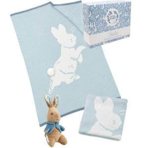 A soft blue knitted baby blanket with large peter rabbit in the knit and a peter rabbit toy gift set
