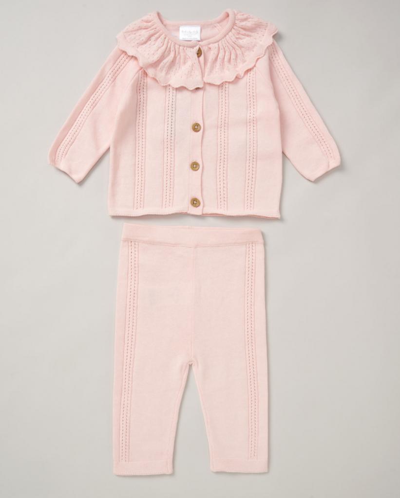 A soft pink knitted baby girl clothing outfit of cardigan and trousers