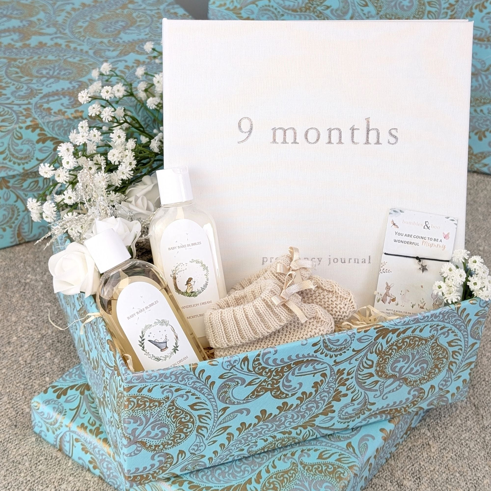 pregnancy gifts box with nine month baby journal, organic baby wash, baby booties and a little wishes bracelet for mum to be.