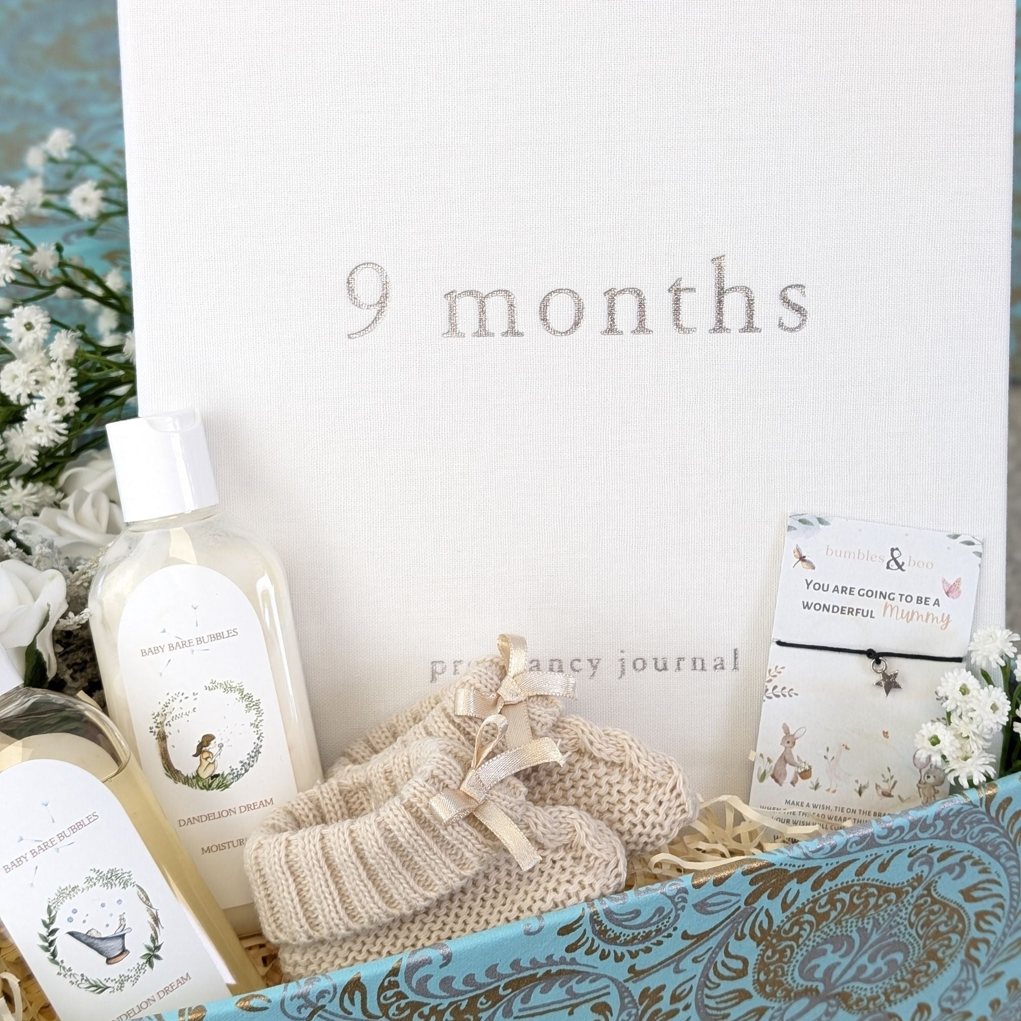 pregnancy gifts box with nine month baby journal, organic baby wash, baby booties and a little wishes bracelet for mum to be.