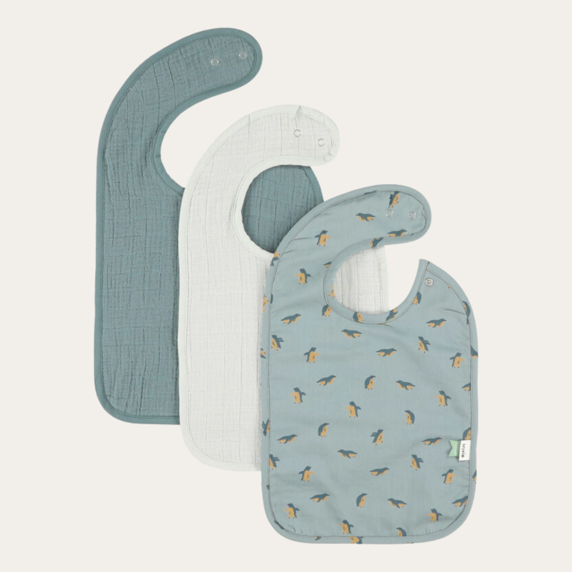 3 pack of easy wipe muslin baby bibs. One with penguin print, one pale grey and one in petrol blue green. Perfect for feeding and bottle times. 100% organic cotton. 