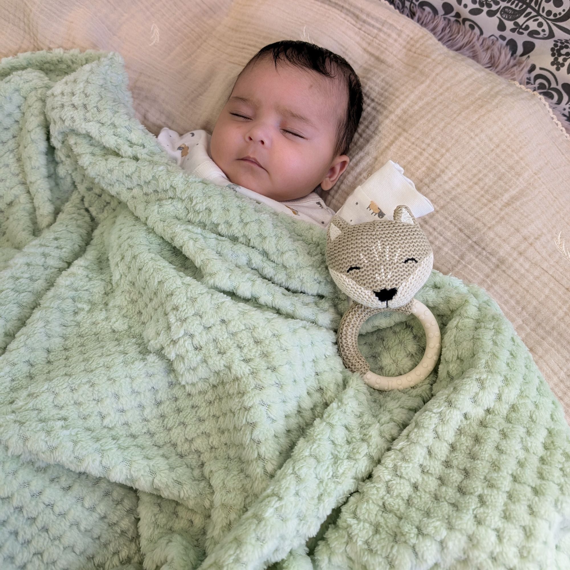 A soft warm baby blanket wrap in a light sage green colour