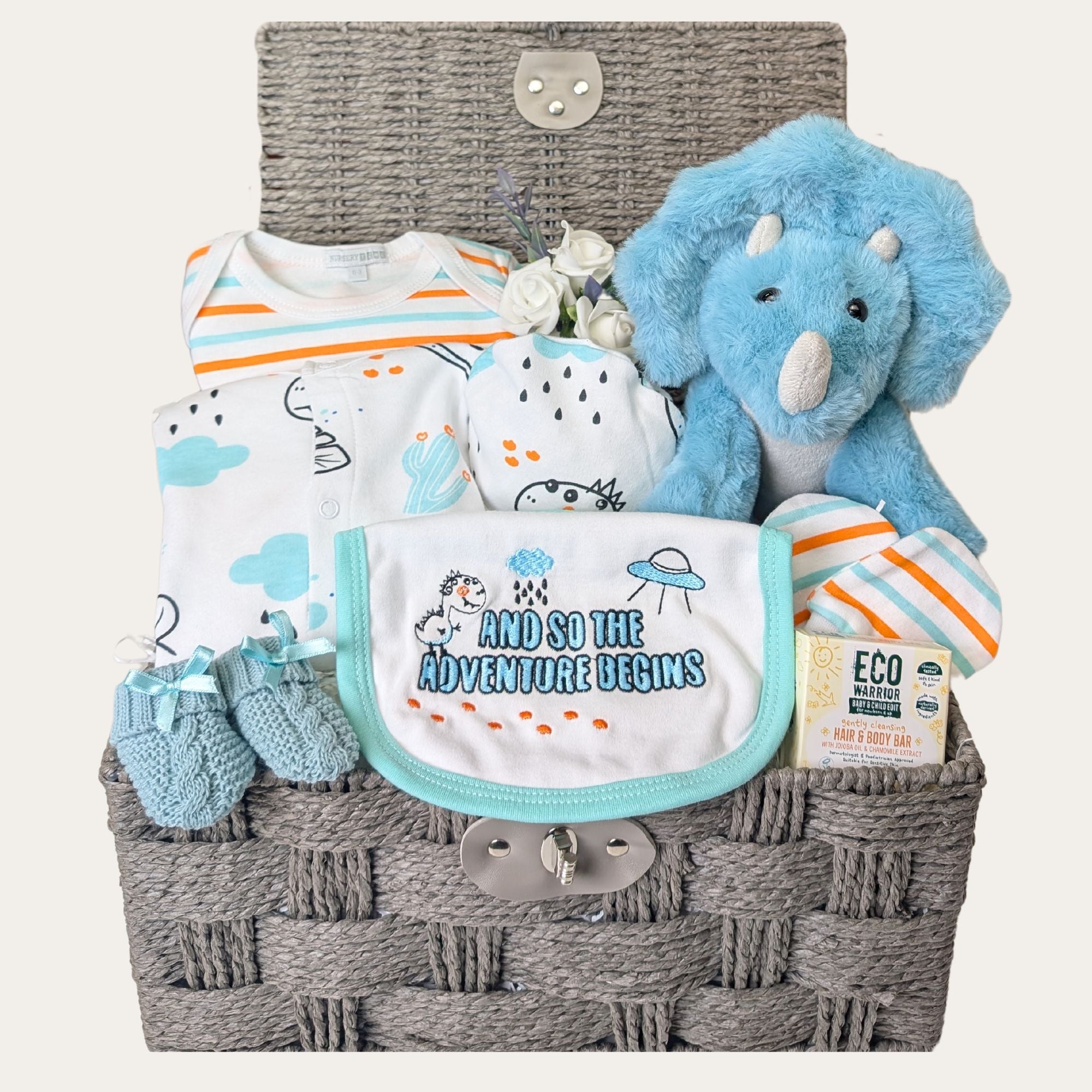 baby boy gift hamper gift with dinosaur themed clothing set, dinosaur soft toy, baby skincare and baby knit booties.