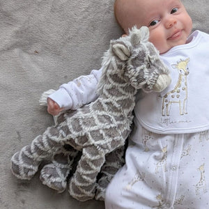 Grey giraffe mary meyer baby toy, with a smiling baby.