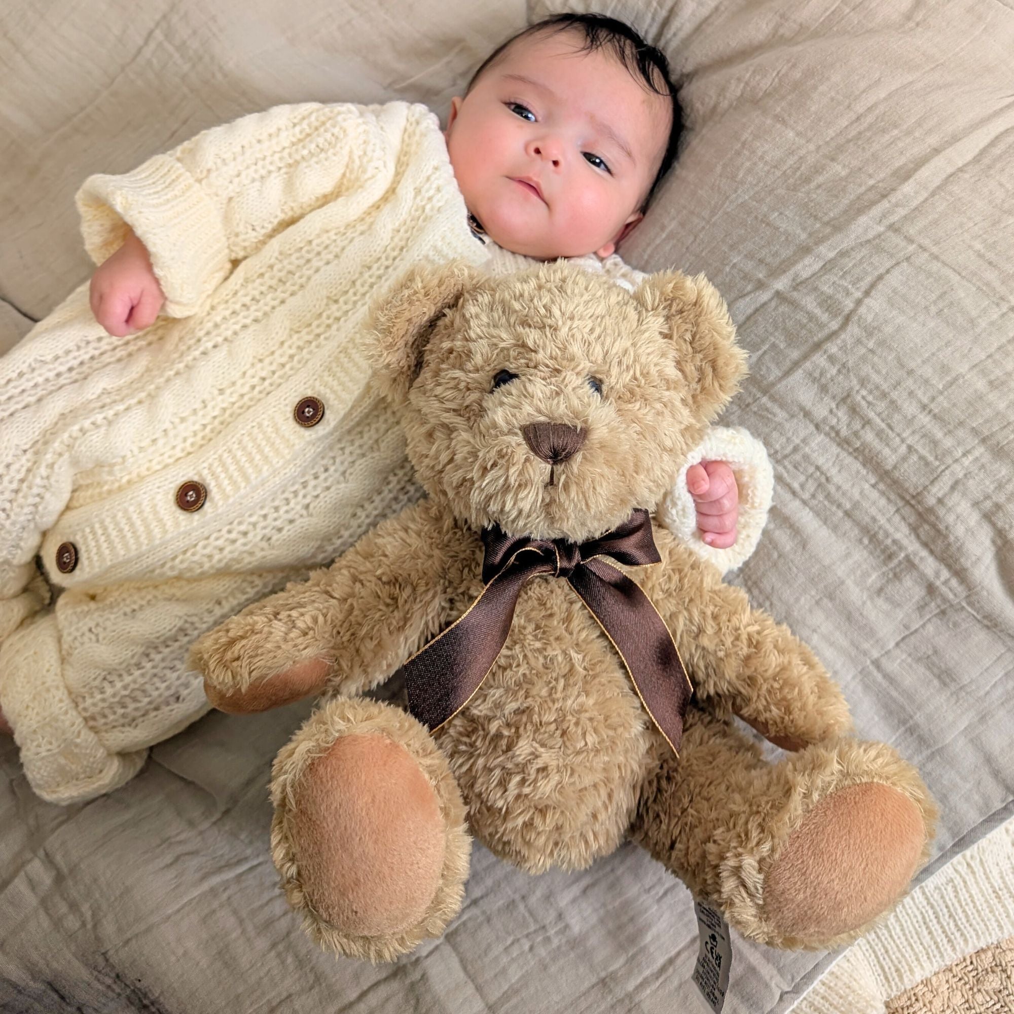 large brown teddy bear with bow around neck