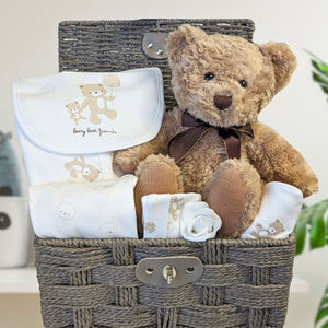 Baby Gifts teddy bear hamper basket with white baby clothing set for a newborn.