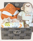 Unisex baby hamper basket with gifts of monkey soft toy wearing a personalised jumper and fox theme.