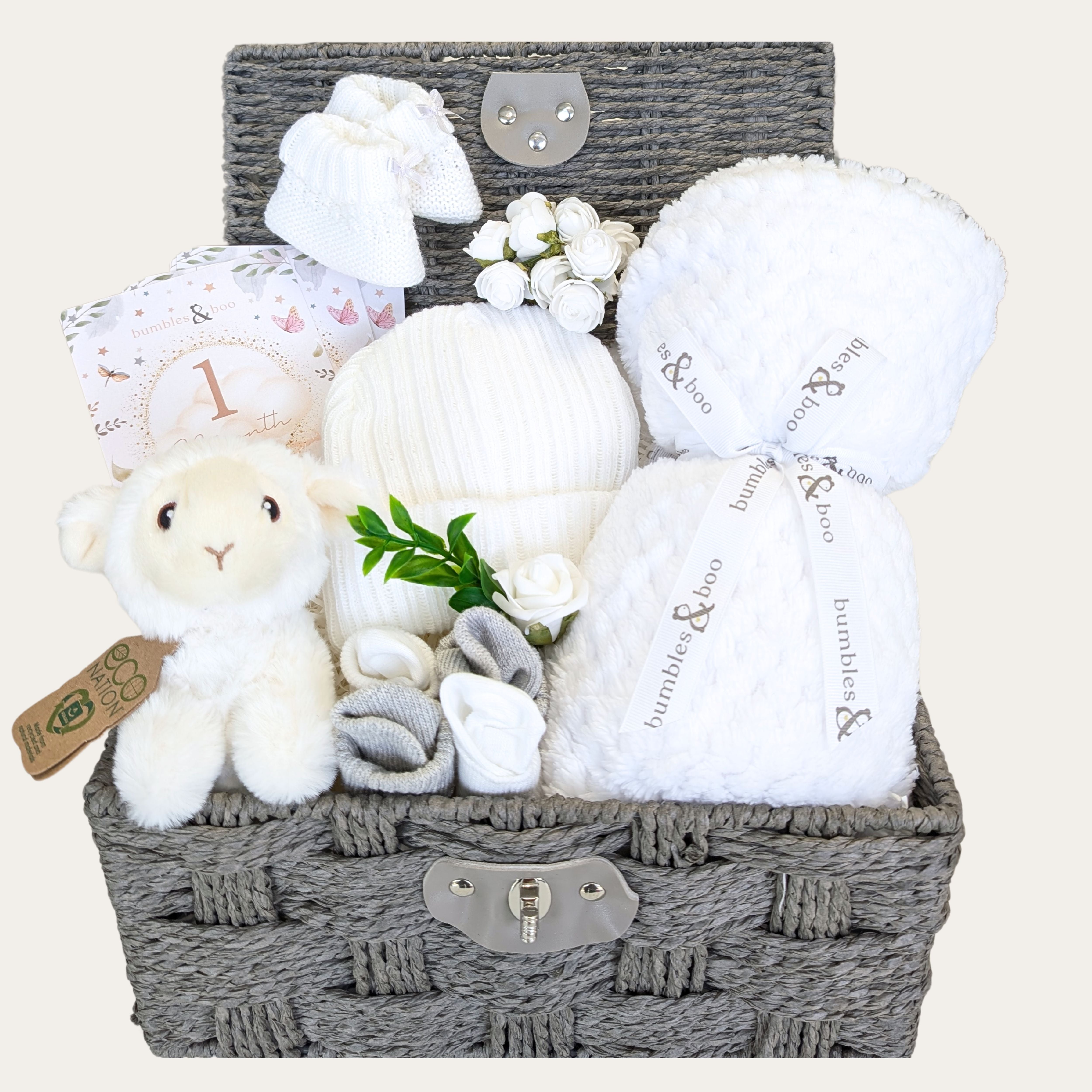 baby gifts hamper with baby blanket in white, rattle lamb toy, baby hat, mittens and booties and baby milestone cards.