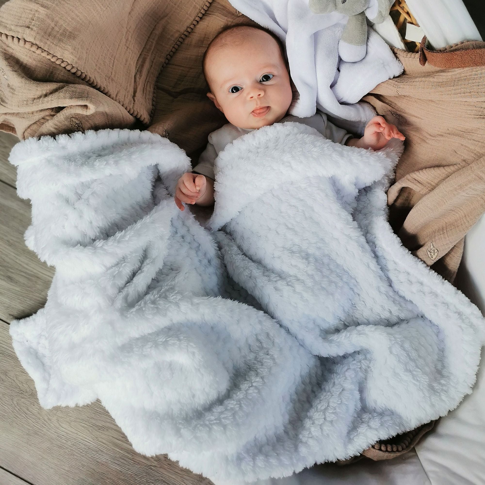 White waffle baby blanket wrapped around a cute baby.