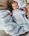 White waffle baby blanket wrapped around a cute baby.