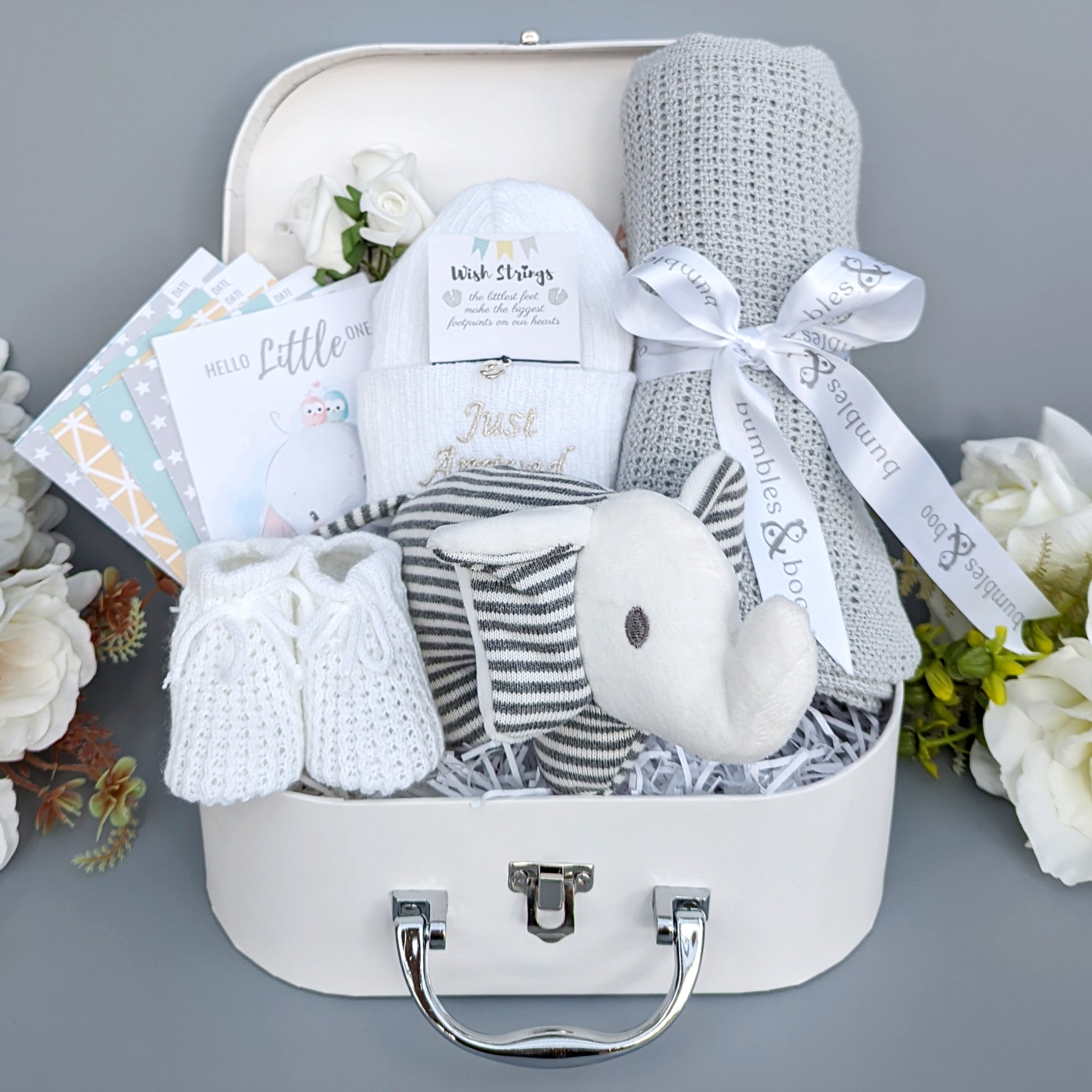 Baby hamper gift with baby blanket, baby knit hat, baby booties and milestone cards.