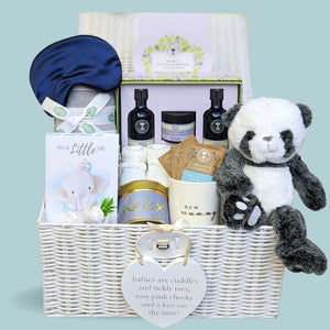 New mum gifts hamper packed with pamper presents in a wicker basket. With Neal's Yard and panda soft toy.